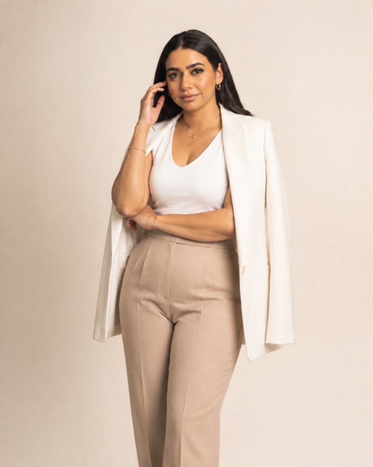 Amel Amamou, Tunisian entrepreneur and business builder, standing in a cream blazer and tan trousers.